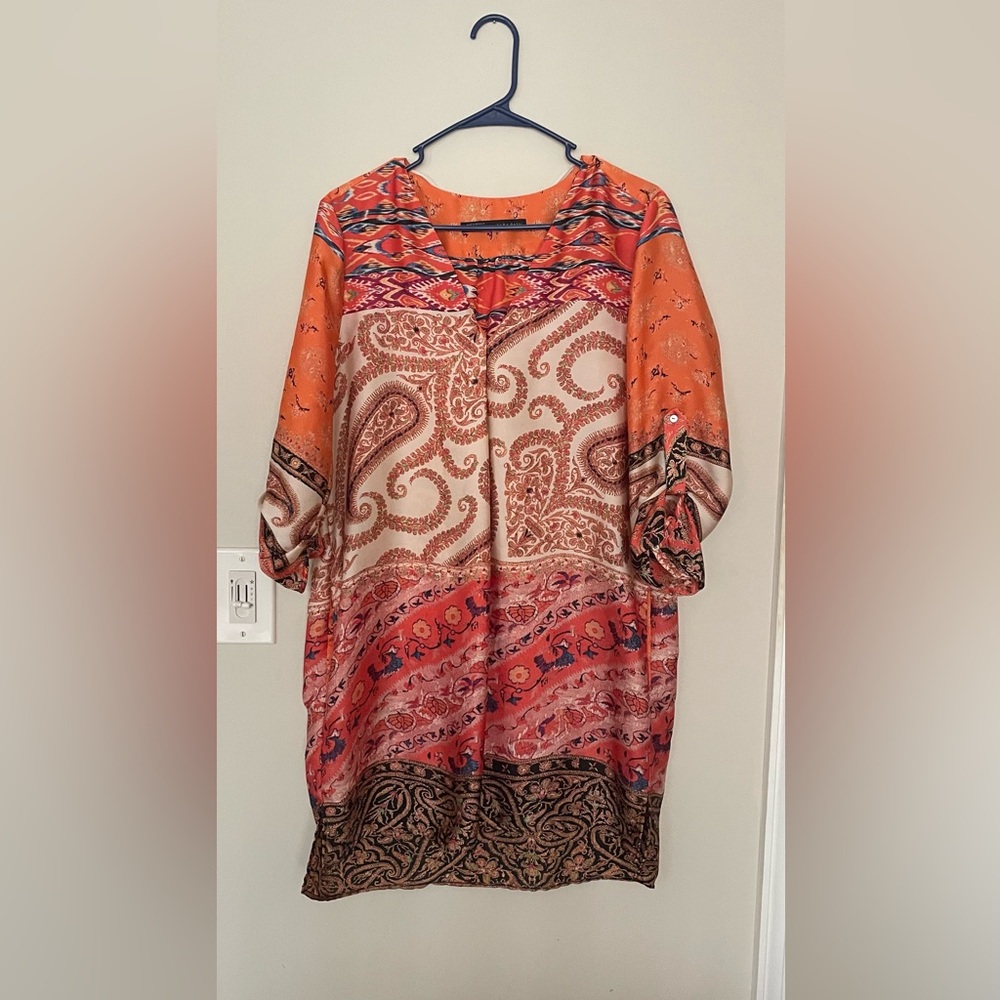 Dress with design in different shades of orange, black and cream.